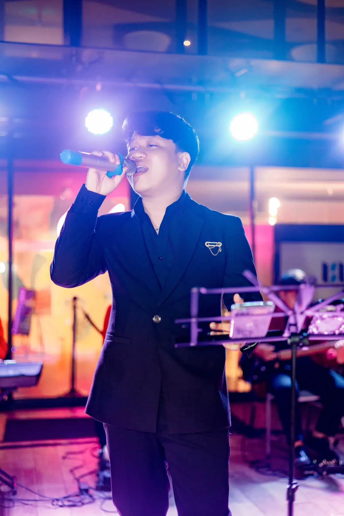 Male singer on stage under blue spotlights