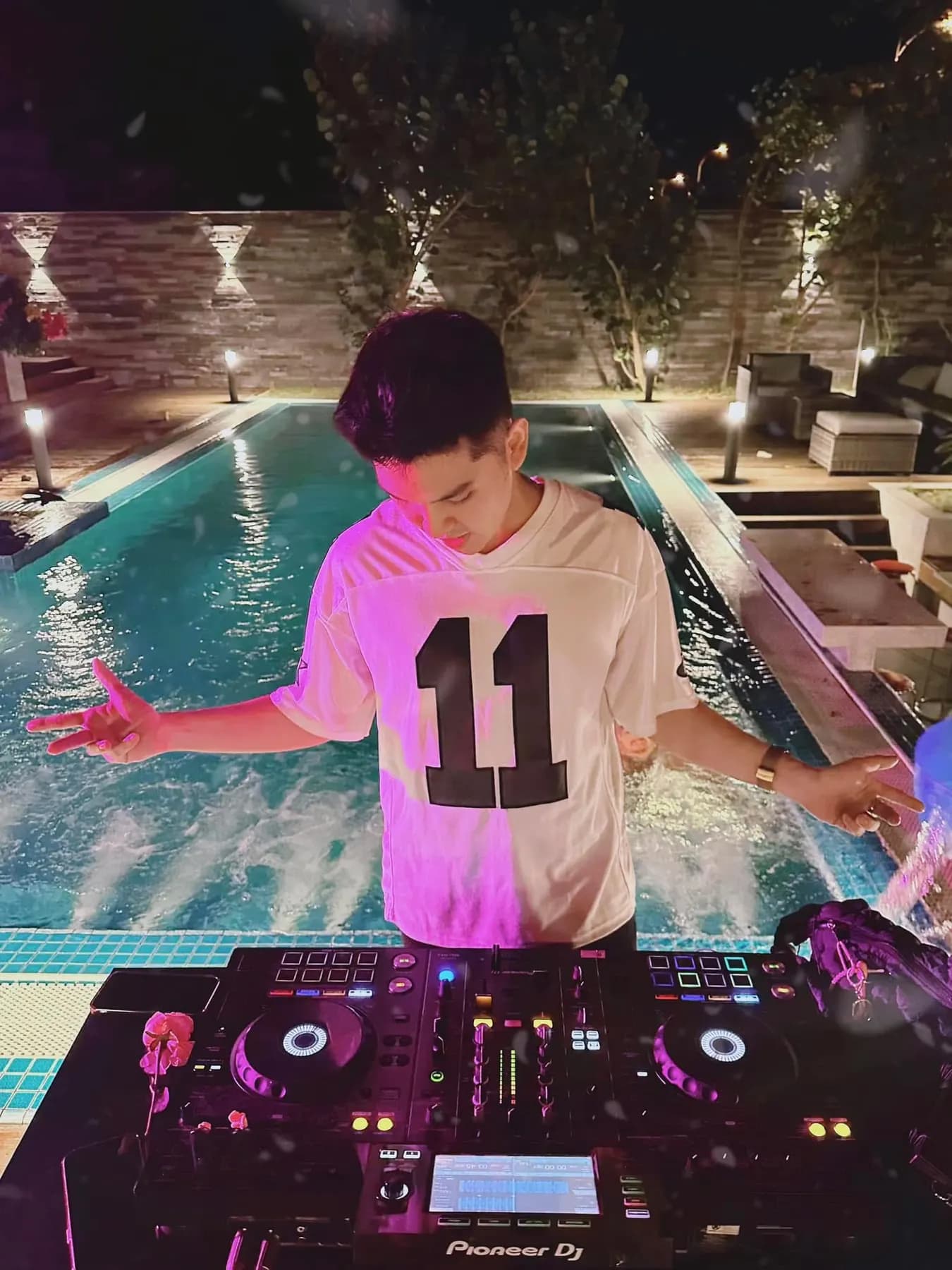 DJ playing a poolside set at night