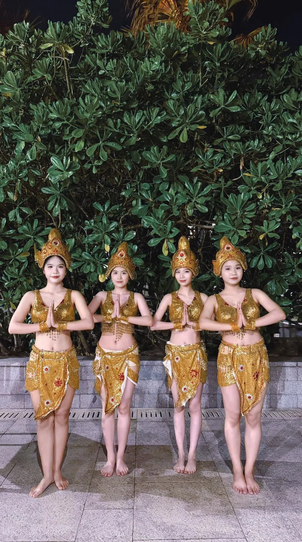 Four dancers in gold Cham costumes