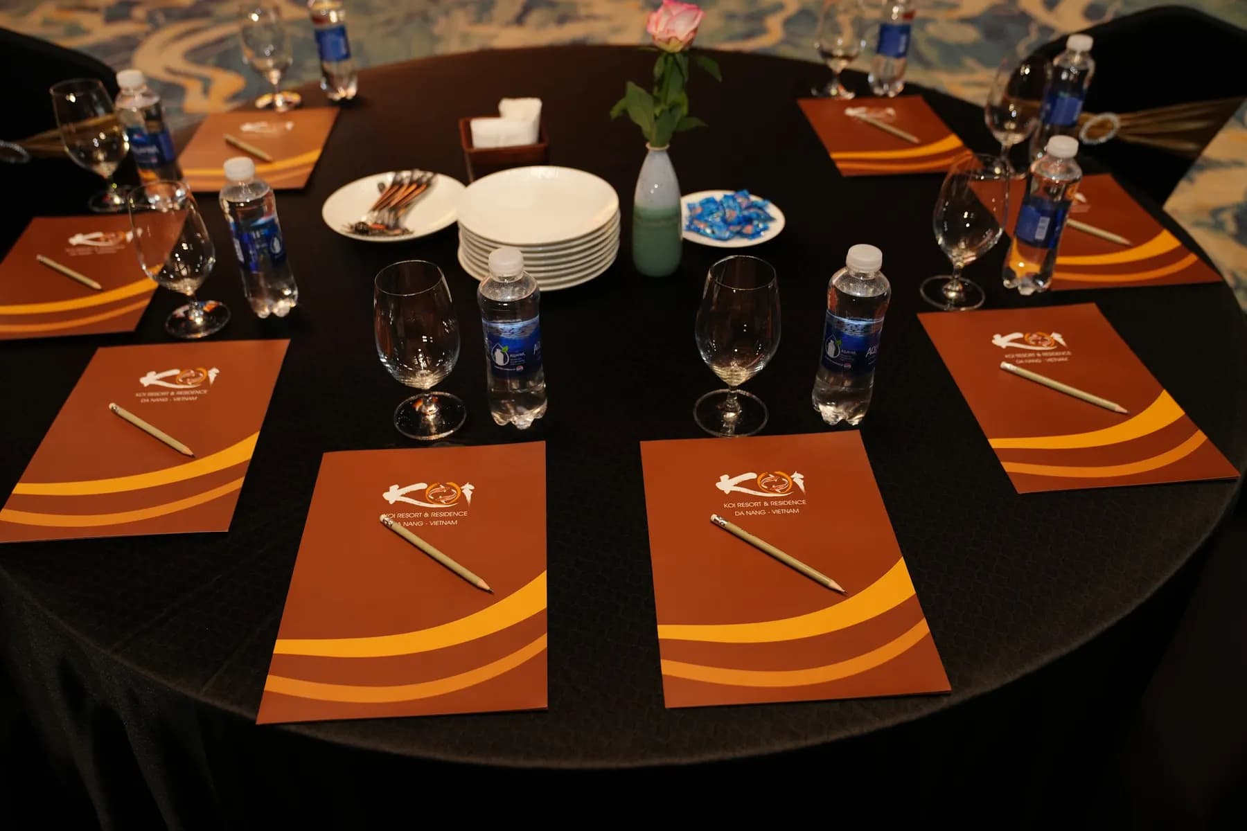 Round table set with branded folders and glassware