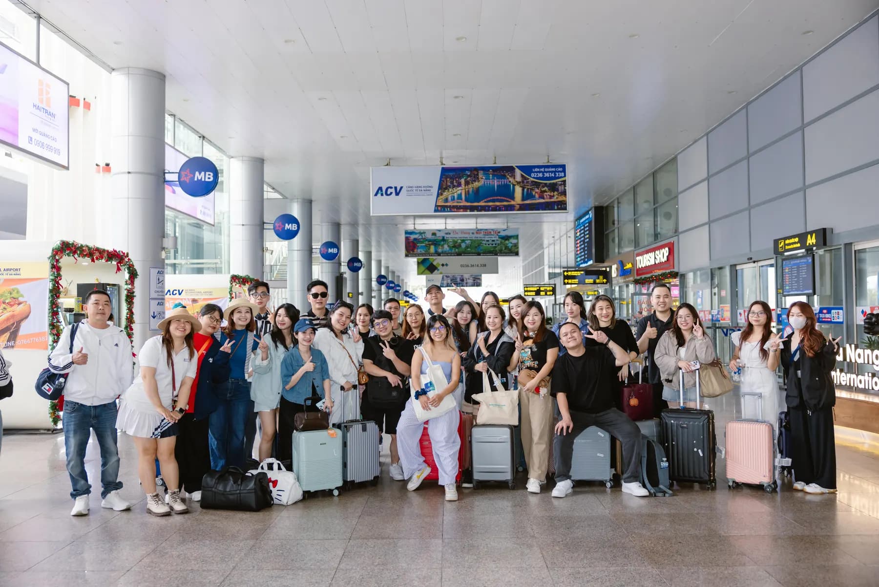 L'Oréal guests with their suitcases in a group photo at Da Nang airport arrivals