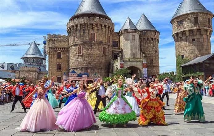 Costumed dancers parading in front of the Ba Na Hills castle